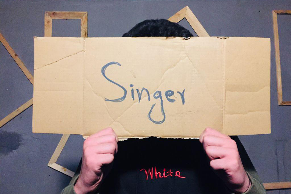 artists_at_risk_article_header A person holding a sign in their hands that says "Singer"